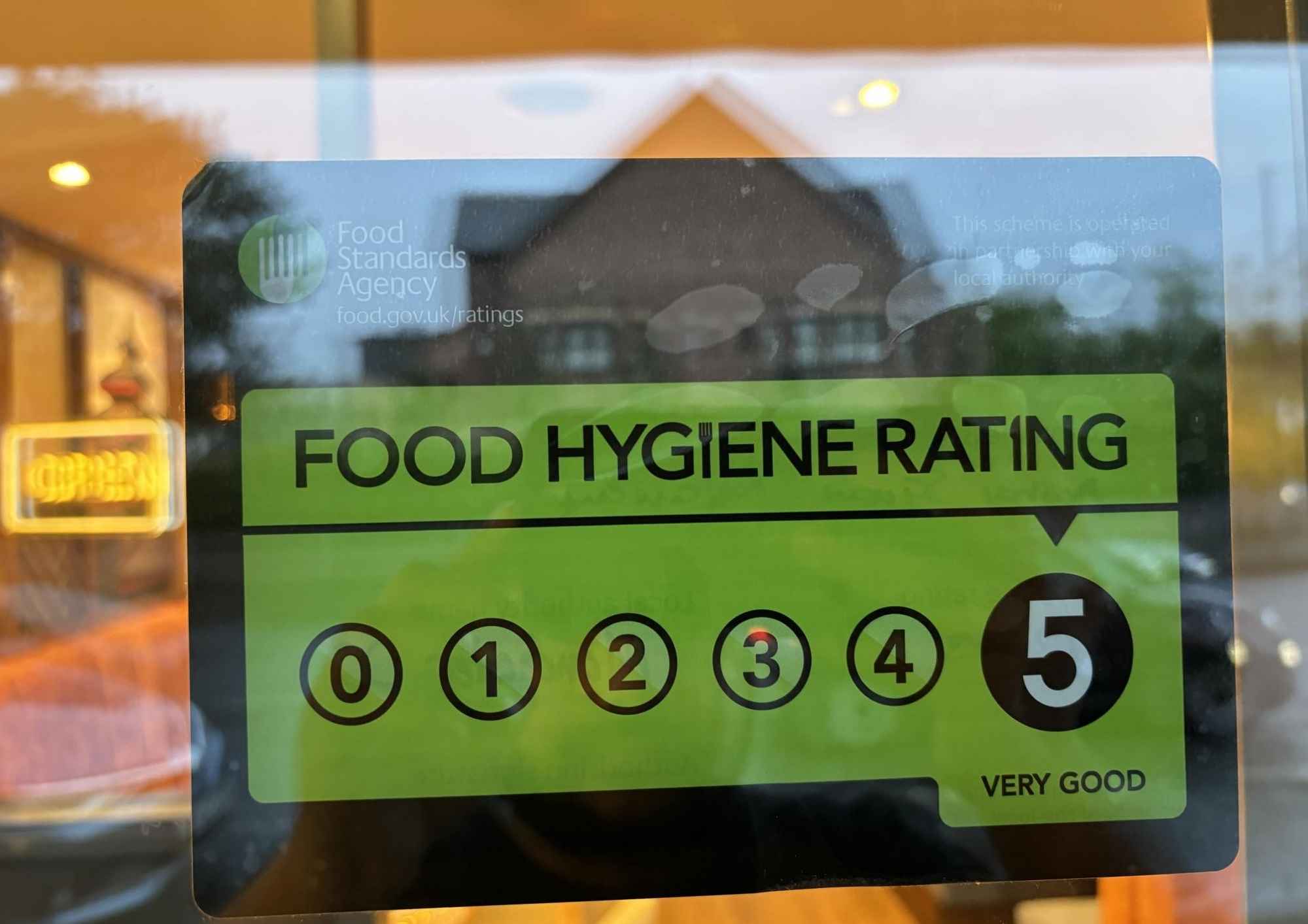 Food hygiene rating display showing a 5-star rating system on a restaurant window.